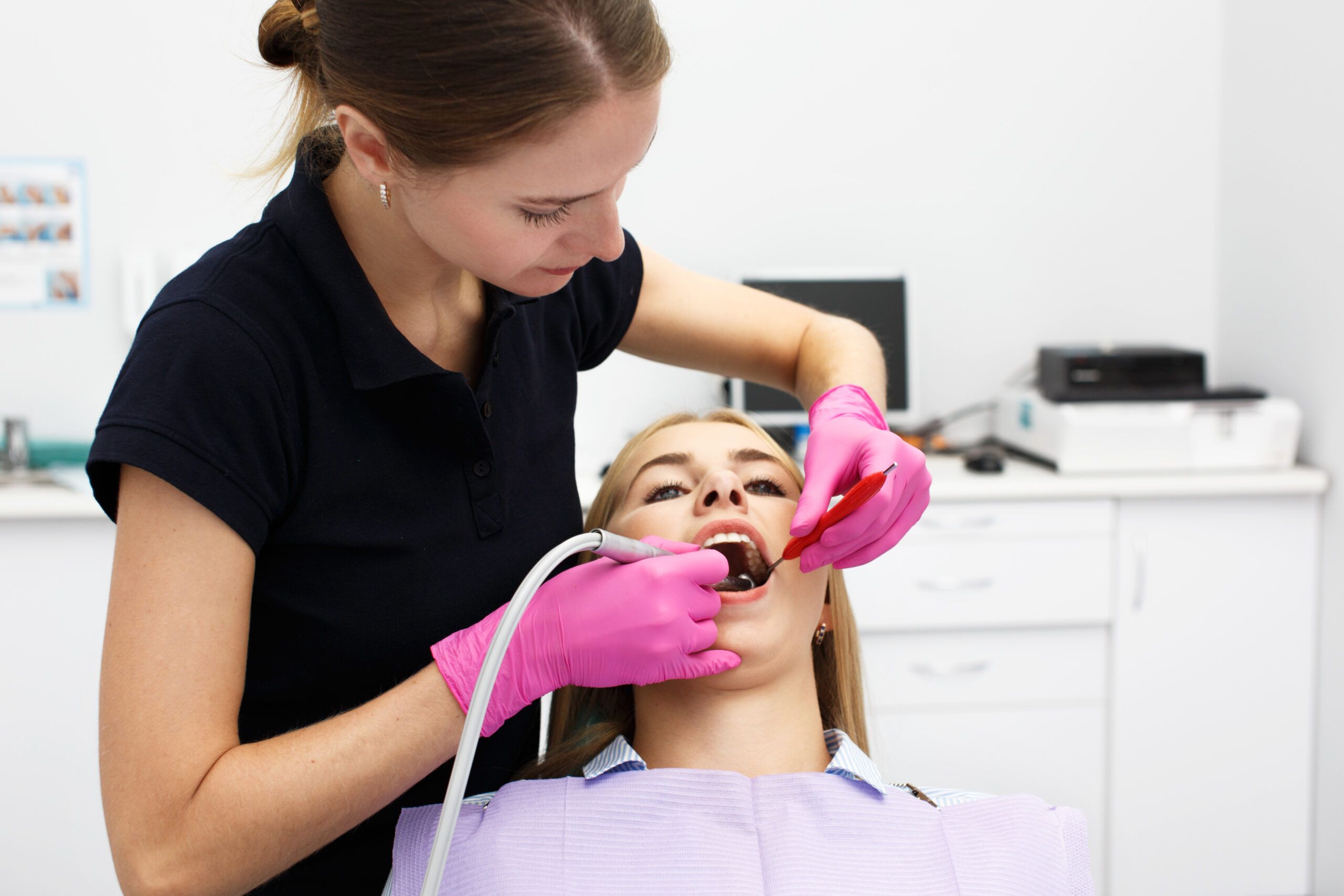 Female dentist treating her patient teeth